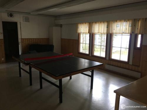 a ping pong table in a room with windows at NORDIC LAKES OY/AB in Taivalkoski
