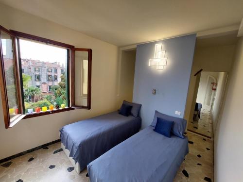 1 dormitorio con 2 camas y ventana en Residenza Donini in Venice Suite 1, en Venecia
