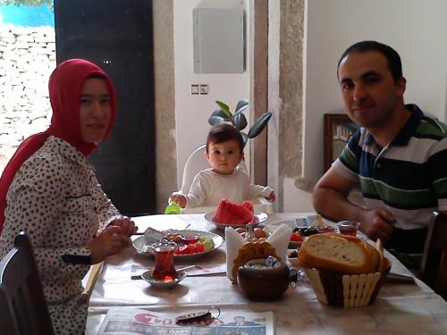 a man and a woman sitting at a table with a baby at Demirkapi Konak Hotel in Safranbolu