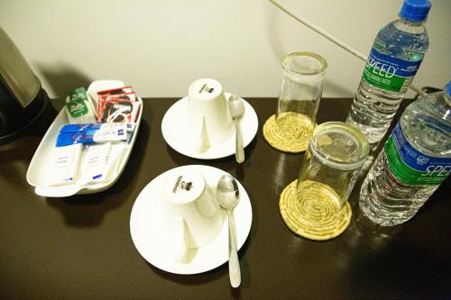 a table with plates and cups and water bottles at Amelia Resort in Sigiriya