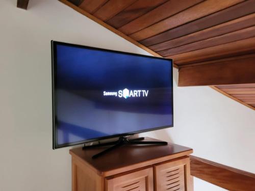 a flat screen tv sitting on top of a wooden stand at Apto Duplex com Mezanino in Juquei