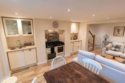Una cocina y una sala de estar con un sofá y una mesa. en The Snug, en Great Malvern