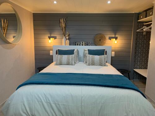 a bedroom with a large bed with blue and white pillows at Country house Au Ballet des Hirondelles in Herve
