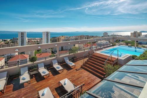 a rooftop deck with a swimming pool on a building at Dioklecijan Hotel & Residence in Split