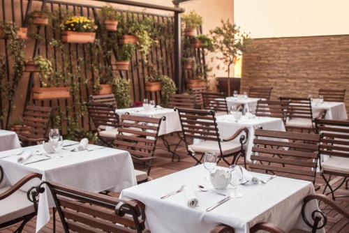 a dining room with white tables and chairs at Dioklecijan Hotel & Residence in Split