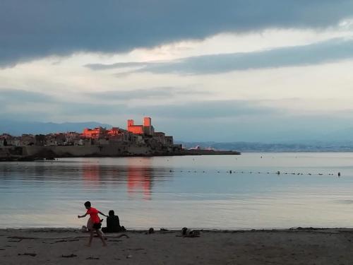 two people walking on the beach near the water at Appartement rooftop vue mer in Antibes