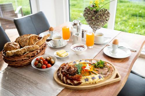 una mesa con desayuno de huevos, pan y zumo de naranja en Possegger Hideaways, en Zödl