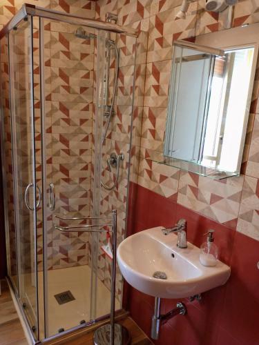 ein Bad mit einem Waschbecken und einer Dusche in der Unterkunft Mi casa tu casa in Formia