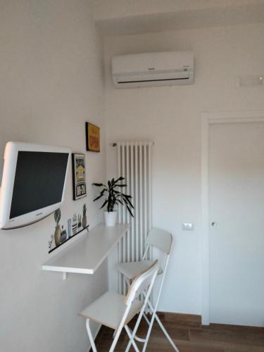 een witte kamer met een tv en 2 stoelen bij Mi casa tu casa in Formia