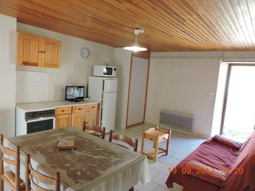 une cuisine et une salle à manger avec une table et une table et des chaises dans l'établissement Gite au pied du mont Lozère 3, à Mas-dʼOrcières
