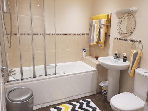 a bathroom with a tub and a toilet and a sink at Beach View Ballycastle Escape in Ballycastle