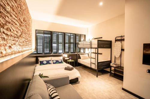 a bedroom with a bed and a couch at Chulia Heritage Studio in George Town
