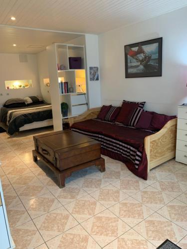 - un salon avec un lit et un canapé dans l'établissement Charmant Studio meublé, à Montignac-Charente