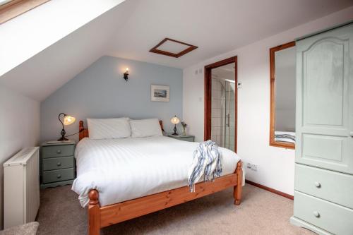 ein Schlafzimmer mit einem Bett, einer Kommode und einem Fenster in der Unterkunft Swift Cottage in Broadhempston