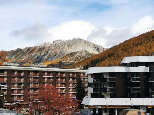 ein Gebäude mit einem Berg im Hintergrund in der Unterkunft Grand studio 4 à 6 personnes, au pied des pistes in Vars