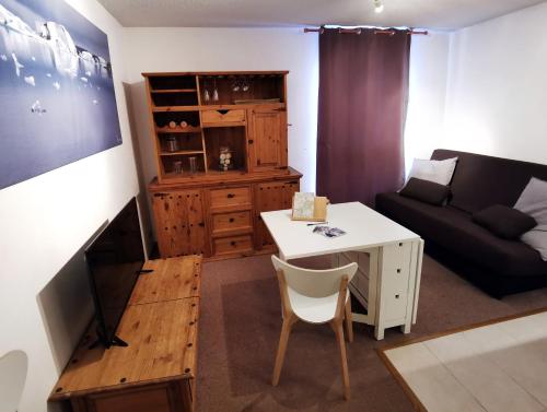 ein Wohnzimmer mit einem Sofa und einem Tisch in der Unterkunft Grand studio 4 à 6 personnes, au pied des pistes in Vars
