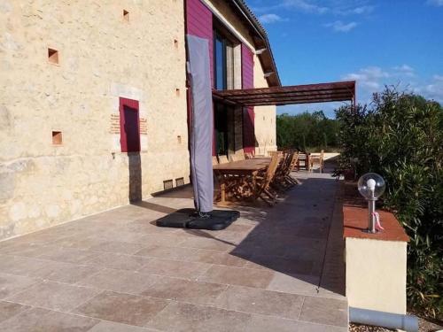 a patio outside of a building with a table at exceptionnel loft style industriel tout équipé 15 personnes avec piscine et jacuzzi in Villebramar