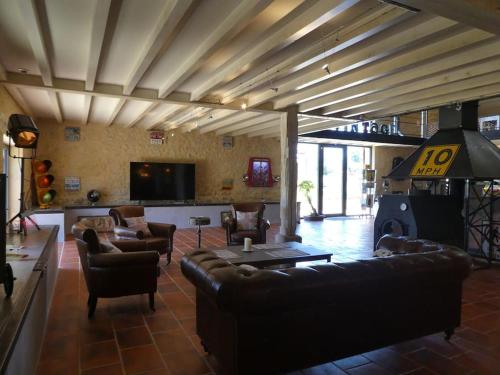 a living room with leather couches and a tv at exceptionnel loft style industriel tout équipé 15 personnes avec piscine et jacuzzi in Villebramar