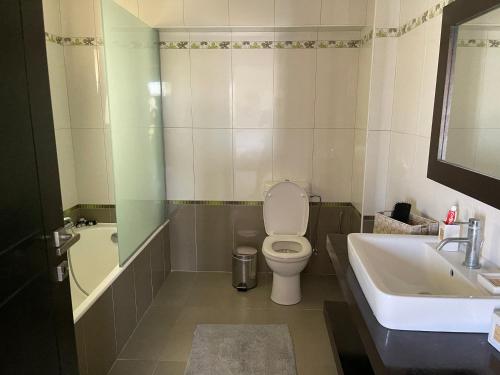 a bathroom with a toilet and a tub and a sink at Breathtaking view guesthouse in Psalidi