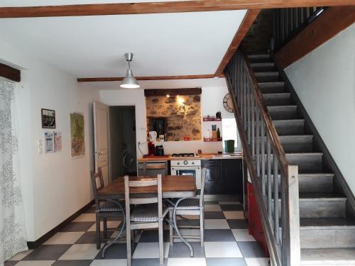 a kitchen with a table and chairs and a staircase at Gîte de la Grenouille - 5-7 places - vallée d'Aure in Lortet