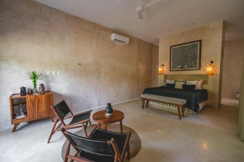 トゥルムにあるWakax Hacienda - Cenote & Boutique Hotelのベッドルーム1室(ベッド1台、テーブル、椅子付)
