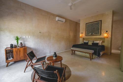 a bedroom with a bed and a table and chairs at Wakax Hacienda - Cenote & Boutique Hotel - Small Luxury Hotels of the World in Tulum