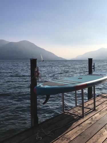 a surfboard sitting on a dock in the water at Casa Conti al Lago in Ronco s/Ascona - Porto Ronco
