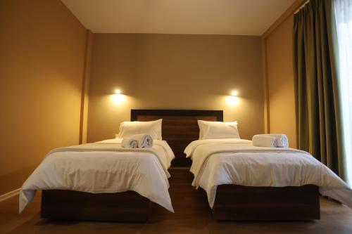 a bedroom with two beds with white comforters at House of Horses Shtepia e Kuajve in Korçë