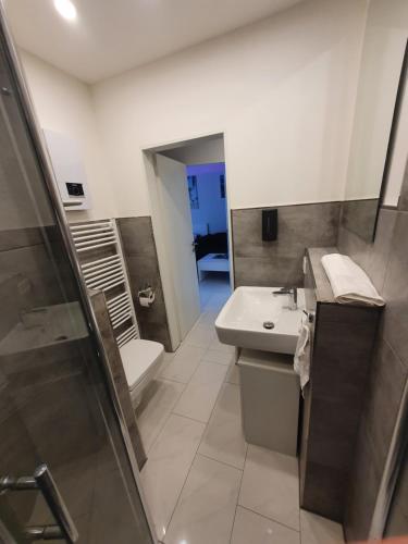 ein Bad mit einem Waschbecken und einem WC in der Unterkunft Miami Apartment in Paderborn