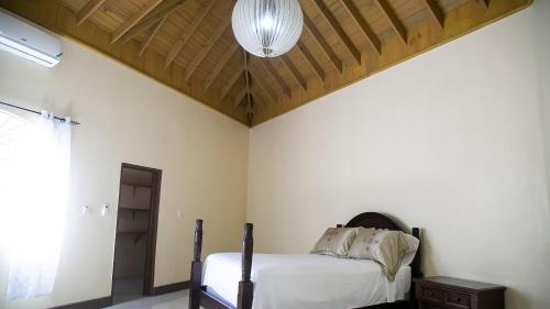 a bedroom with a bed and a wooden ceiling at Ocean View Terrace in Montego Bay