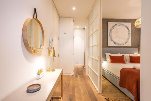 - une petite chambre avec un lit et un miroir dans l'établissement Chic Tailor Made Flat in Chiado, à Lisbonne