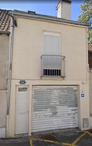 a building with a garage door and a window at Le Berry - Maison de ville - Parking privé in Bourges