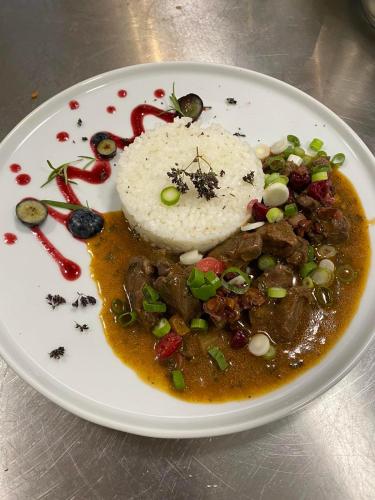 a plate of food with meat and rice on it at Apartmány Planina Predná Hora in Predná Hora