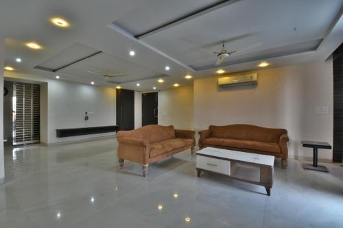 a living room with two chairs and a coffee table at The Clovers Inn in Patna