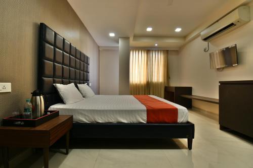 a bedroom with a large bed and a television at The Clovers Inn in Patna