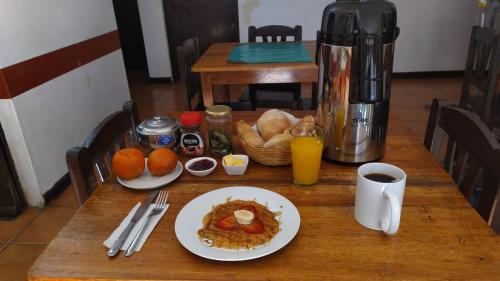 una mesa con una bandeja de comida para el desayuno y una cafetera en Mirador Backpackers B&B, en Huaraz