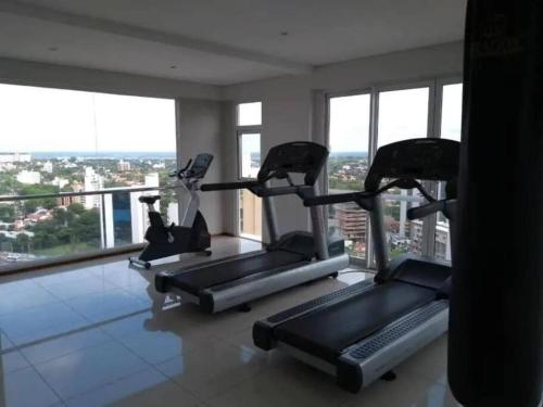 a gym with three tread machines in a room with windows at Z SHOPPING LA GALERIA APT Great Location! Low price! Full amenities! in Asuncion