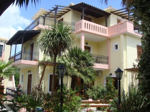 a large building with palm trees in front of it at PHILIPPOS Hotel Apartments in Nikiana