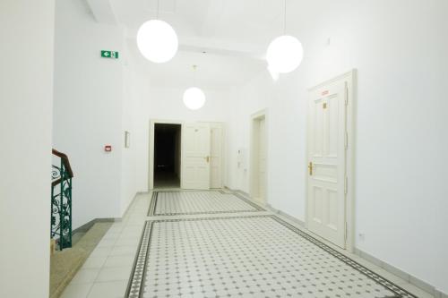 an empty hallway with white walls and white floors and white doors at Residence Dlouha - Old Town in Prague
