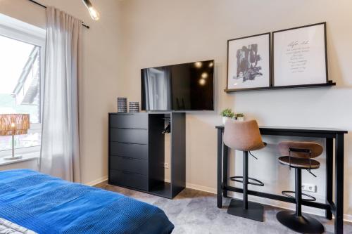a bedroom with a bed and a desk with a television at Apartment Cozy in Porta Westfalica