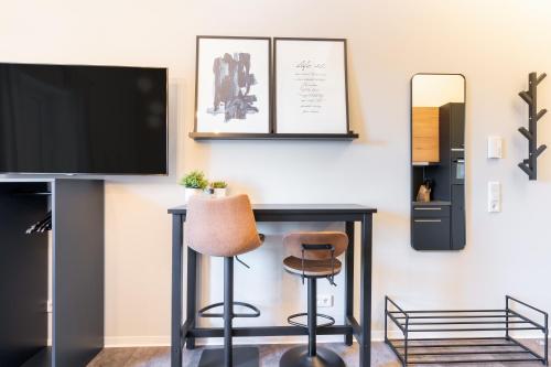 a living room with a desk with a television and a stool at Apartment Cozy in Porta Westfalica