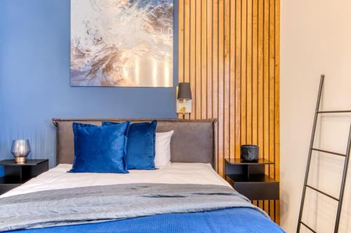 - une chambre avec un lit et des oreillers bleus dans l'établissement Apartment Cozy, à Porta Westfalica