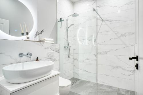 a white bathroom with a sink and a shower at Apartment Homely in Porta Westfalica