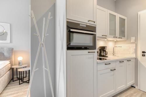 a kitchen with white cabinets and a microwave at Apartment Homely in Porta Westfalica