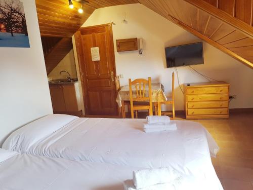 Schlafzimmer mit einem Bett, einem Tisch und einem TV in der Unterkunft Estudi Casa Xulla in Taull