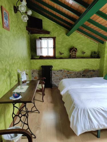 a bedroom with green walls and a bed and a table at Casa La Fonte in Barcia