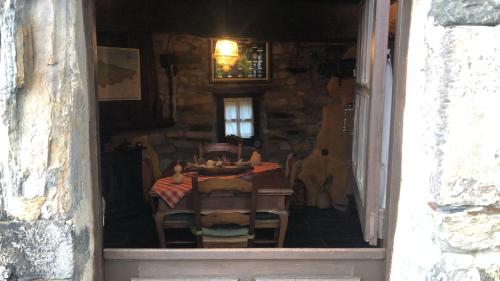 a dining room with a table and chairs in a building at Casa La Fonte in Barcia