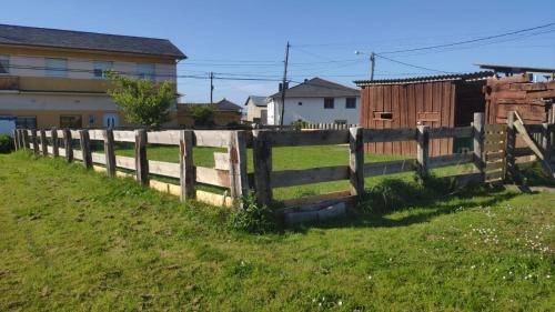 a wooden fence in a field with houses at Casa La Fonte in Barcia