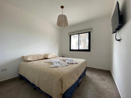um quarto com uma cama num quarto branco em La Escondida Salta 1 em Salta