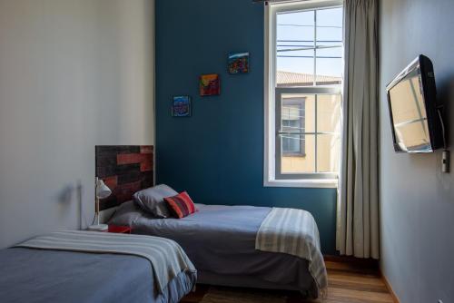 a bedroom with two beds and a window at BO Hotel & Terraza in Valparaíso